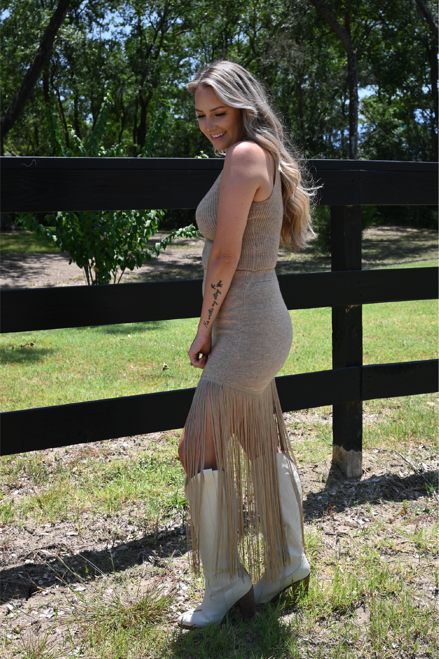 Model is showing the country Chic Fringe Set From the side paired with the ivory knee high MIA boots.