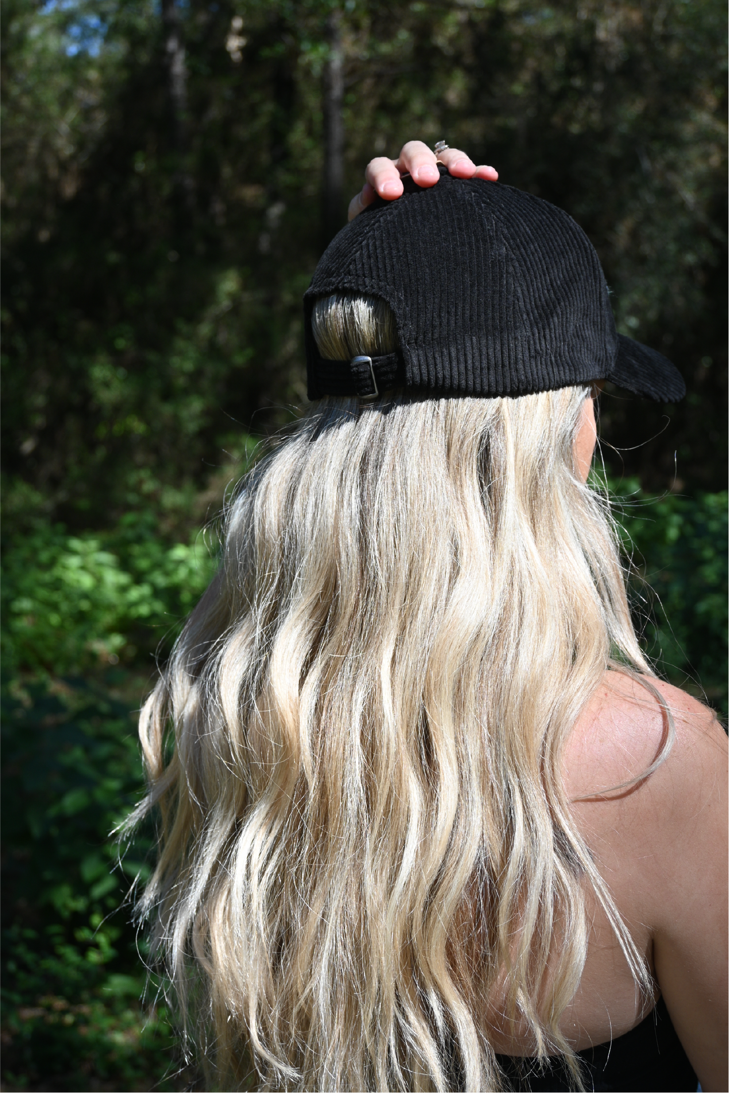 The back of a black corduroy hat on a woman.