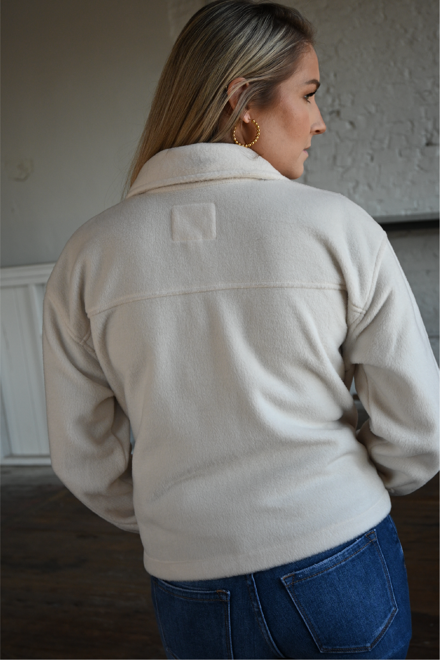 A close up of the back of the cropped ecru jacket paired with the high rise ankle skinny kancan jeans.