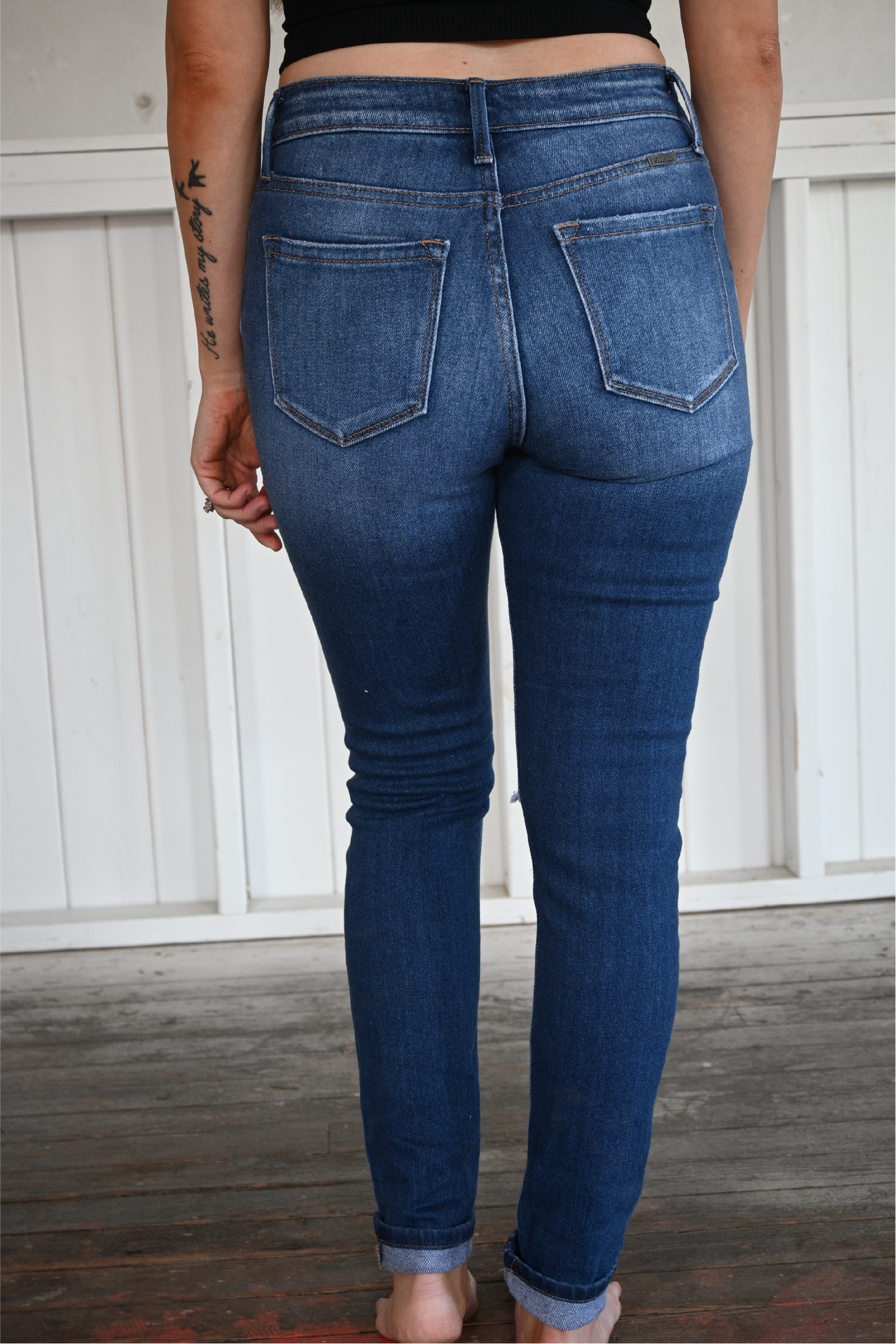 A close up shot of the back of the high rise ankle skinny kancan jeans. Medium wash, two back pockets and cuffed at the bottom.