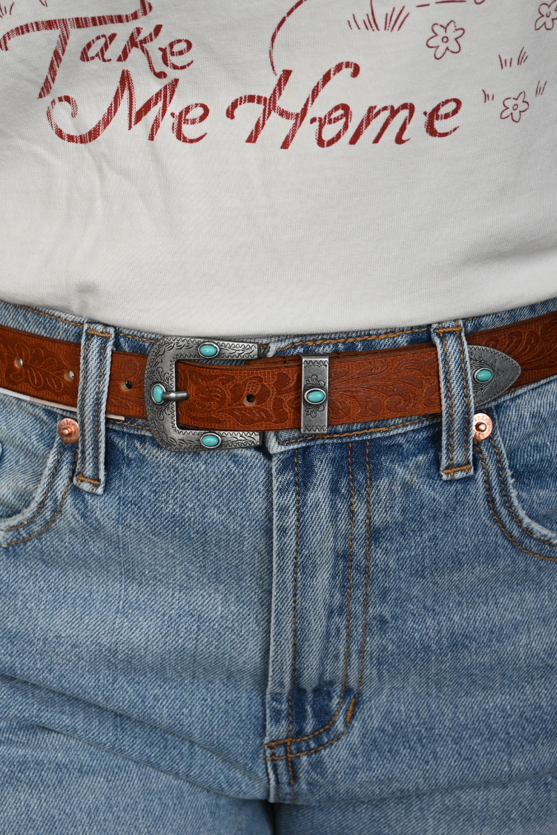 A close up view of a woman wearing a vintage turquoise stone studded belt.