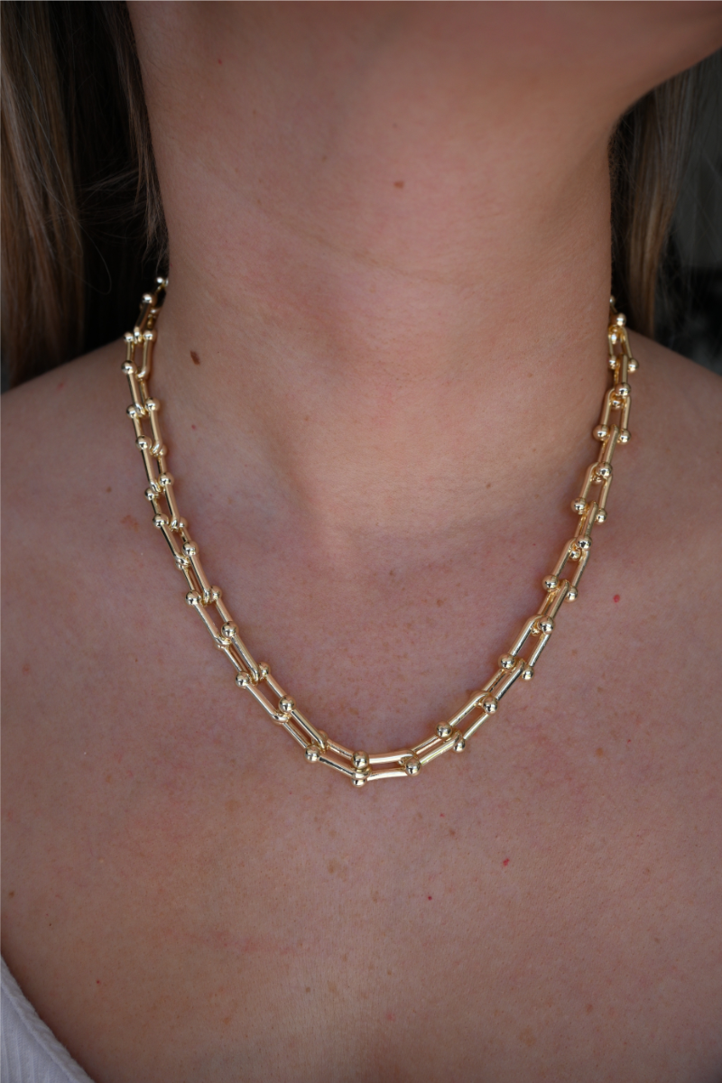 A close up image of a women wearing the gold chain necklace.