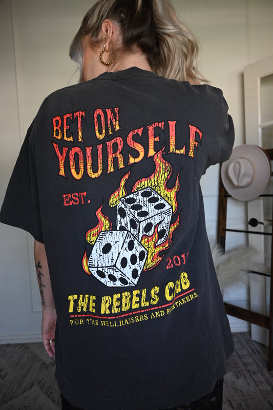 Person wearing a black t-shirt with a graphic design and text.