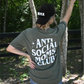 Model is showing the back of the sage colored graphic tee with "Anti Social Moms Club" paired with the Corduroy black "Mama" hat.