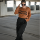 Model is wearing the brown crewneck sweater with the words "Whiskey Weather" in black on the front. It is paired with black satin pants and black heeled boots.