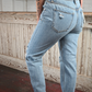 Photo showing bottom portion of woman wearing high rise light wash skinny jeans.