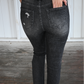 The back of dark grey distressed skinny jeans on a woman.