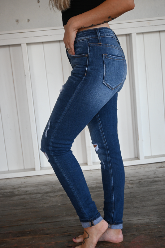 A close up shot of the side of the high rise ankle skinny kancan jeans. medium wash, cuffed at bottom.