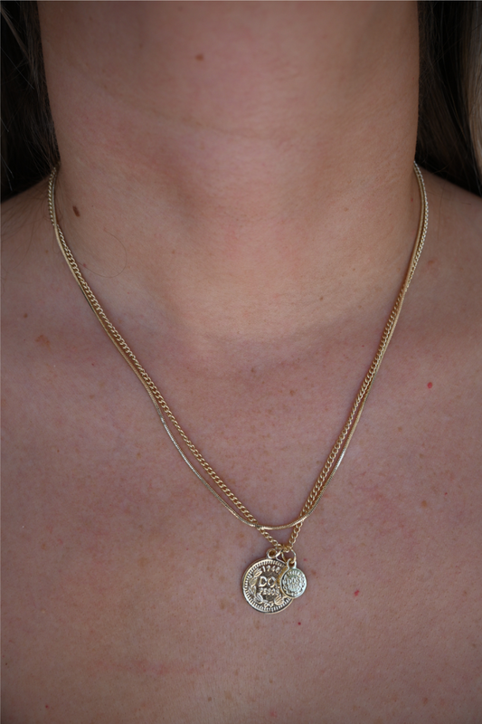 A close up image of a women wearing the layered gold coin necklace.